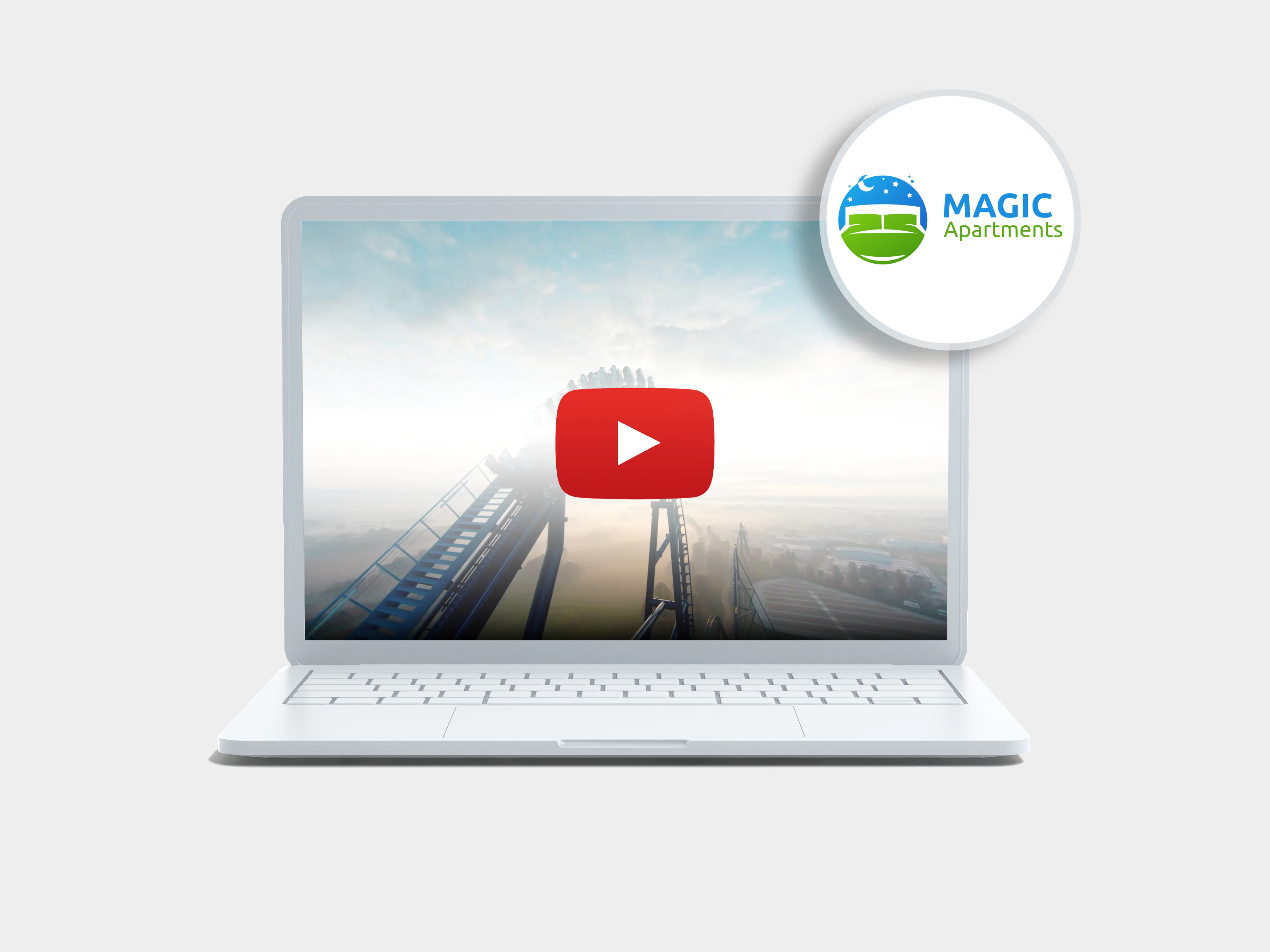 Laptop na szarym tle przedstawiający energylandię i promujący portal Magic Apartments